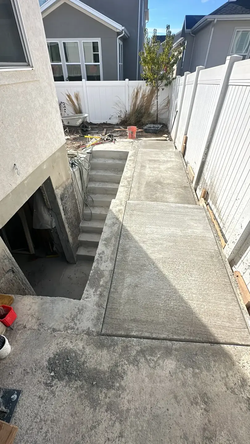 Side walkway beside basement stairs by MD Concrete in Utah