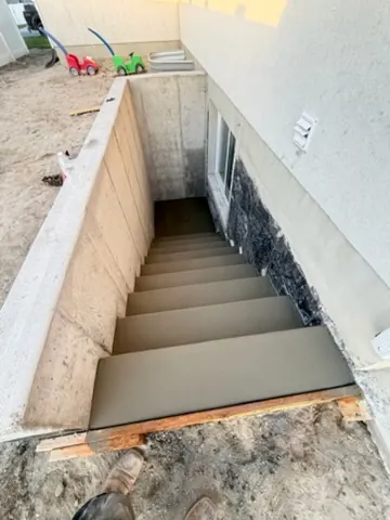 Concrete steps down to a basement by MD Concrete in Utah
