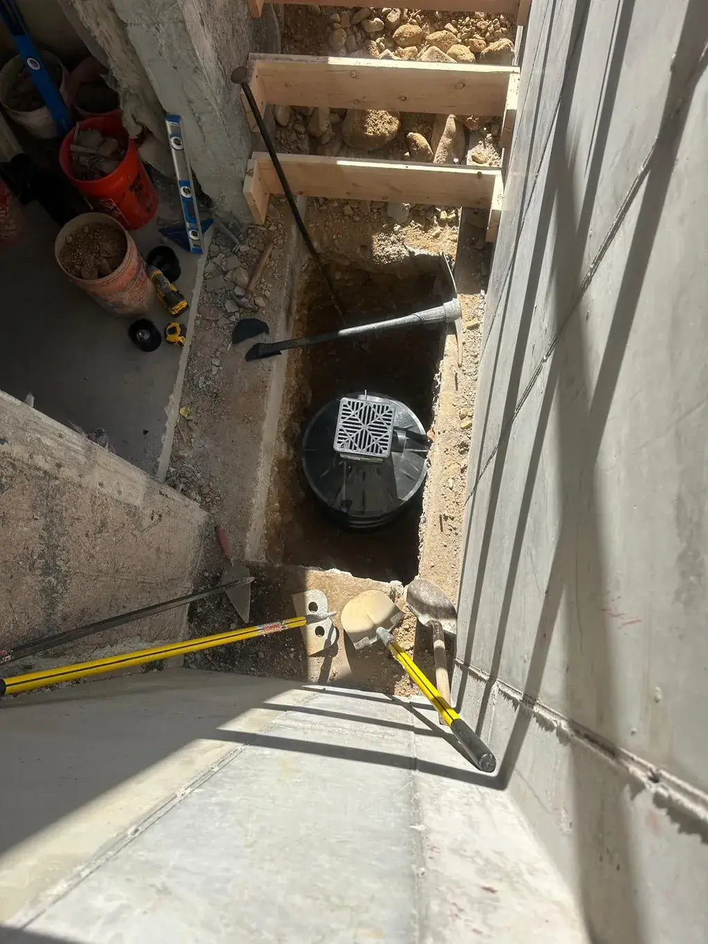 Digging out beside a wall for a walkout by MD Concrete in Utah