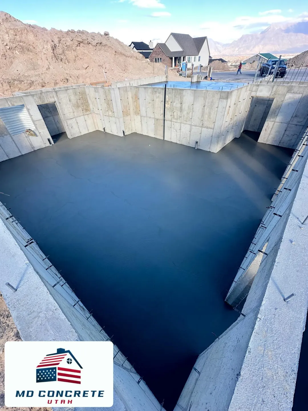 Fresh slab inside tall concrete walls by MD Concrete in Utah