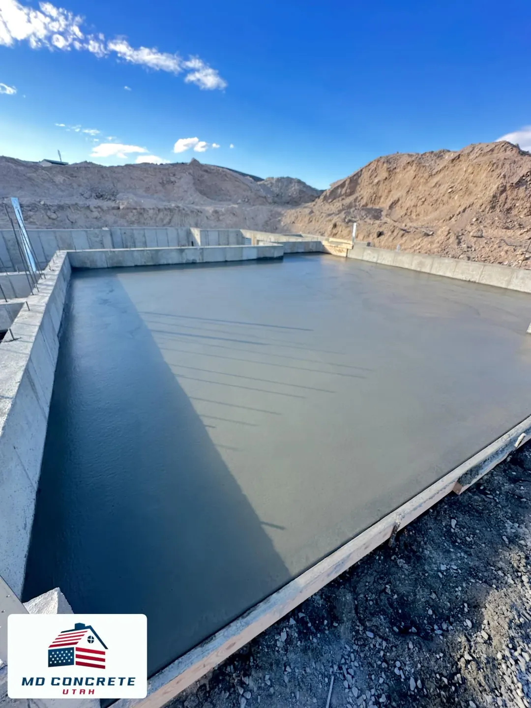 Fresh concrete slab inside foundation walls by MD Concrete in Utah